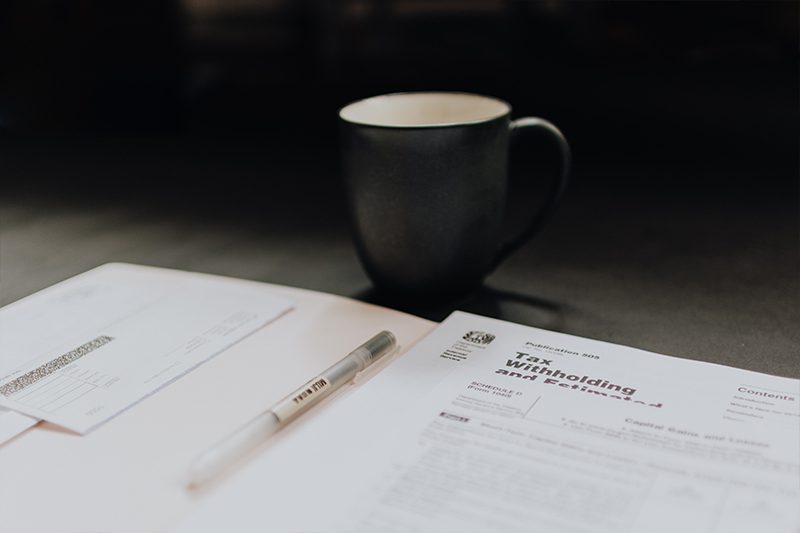 A cup of coffee sitting on top of papers.